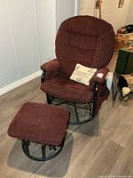 Front view of burgundy upholstered glider rocker with matching footstool