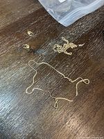 Overall view of both chains and pair of earrings on wooden surface