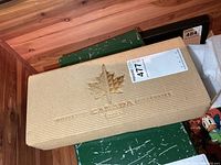 Tan corrugated outer sleeve with gold maple leaf and bilingual text