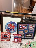 Group shot of framed art, framed painting and two coin sets