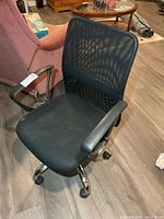 Front view of black mesh office chair showing seat, back, arms and casters