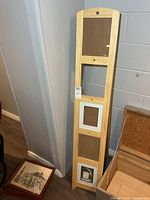 Full view of wooden photo stand leaning against wall