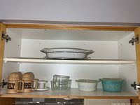 Cabinet view showing baking dish, shakers, glass bowls and two Pyrex casseroles