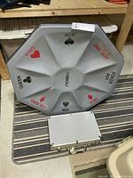 Front view of octagonal Rummoli board with poker chip case underneath