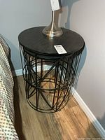 Smaller side table beside bed showing wood top and metal base