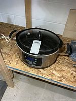 Front view showing Hamilton Beach stainless steel digital slow cooker on shelf