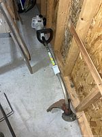 Full view of Stihl FS 38 string trimmer lying on floor, showing shaft, handle and cutting head