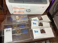 Overview of all six packaged coins on table