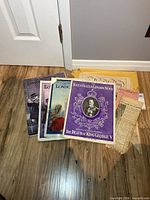 Group shot of four Illustrated London News magazines and envelope with clippings on floor