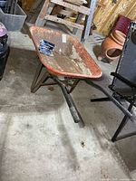 Wheelbarrow side view showing tub, handles, frame