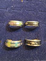 Four spinner rings laid out showing different designs
