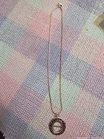 Full view of entire necklace laid flat to show overall length and pendant style