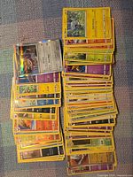 Two tall stacks of assorted Pokémon TCG cards
