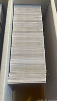 Tall stack of trading cards in long storage box