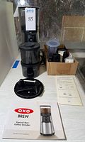Overall lot showing grinder, AeroPress parts, filters, manual