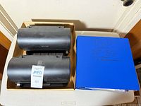 box containing two black disc organizers and blue binder