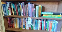 Two bookshelf shelves holding 71 assorted books, Lost Encyclopedia box set visible