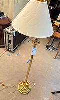 Full view of brass-tone floor lamp with shade