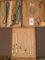 Overview of all trays showing majority of necklaces and pendant cord piece