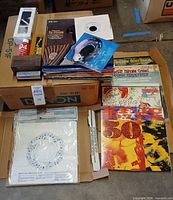 Turntable accessories and vinyl records stacked on Denon boxes