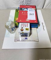 Stacked items showing DVDs, shot glass, Wall-E puzzle on top of Fantasia program