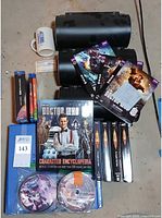 Overall lot showing DVDs, book, mug, disc organizers and binder