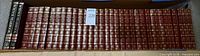 Row of 35 maroon Funk & Wagnalls hardcover yearbooks inside box showing spine titles and years