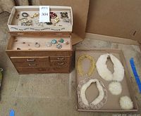 Overview of jewelry box, tray of brooches, rings, and separate tray of collars