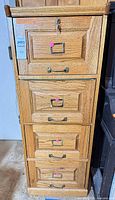 Full front view of oak vertical file cabinet with brass hardware