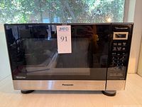 Front view of Panasonic NN-SN67HS microwave showing door, control panel, branding