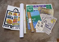 Group shot of folded poster, rolled posters, flyers, and programs