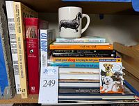 Stack of books, mug and magnet on shelf