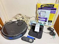 Top view of Eufy RoboVac with dock, remote, adapter, ProTeam bag pack and extension cord visible