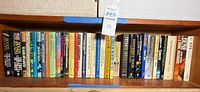 Shelf with approximately 34 science-fiction and fantasy books; visible Herbert, Dick and Zelazny titles