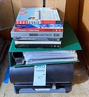 Stack of DVD cover inserts on top of green binder and rotating organizer