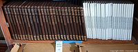 Shelf showing full sets: 26 brown volumes left, 24 white volumes right