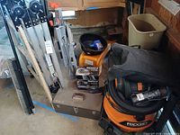 Group view showing ladder, ramps, oil drain pan, DieHard box, toolbox and Ridgid vacuum