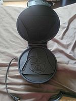 Waffle maker open showing Darth Vader helmet mould on non-stick plate