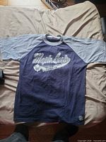 Front view of navy and gray Maple Leafs raglan T-shirt laid flat