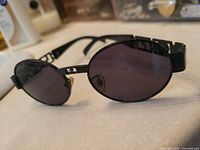 Front angled view showing oval dark gray lenses and black frame