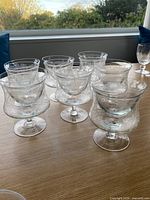 Group of seven etched crystal stem glasses with inserts assembled