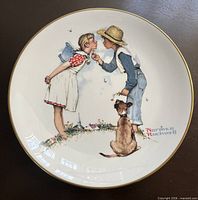 Plate showing boy and girl about to kiss with dog