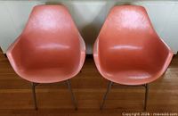 Front view of both orange bucket armchairs