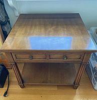 Front view of Henredon walnut side table showing top, drawer, shelf, legs