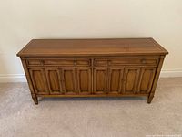 Front view showing drawers, doors, legs, overall finish