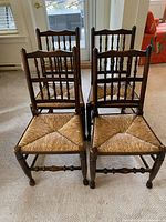 Front view of four oak spindle back chairs grouped