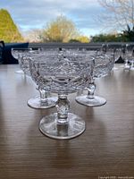 Front angled view of six cut-crystal coupes on table