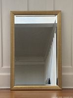 Front view of rectangular gold framed mirror