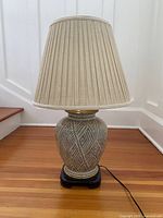 Full view of lamp with shade on wood floor