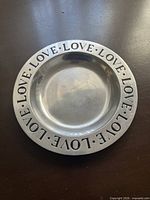 Front view of round Wilton Armetale plate showing "LOVE" inscription around rim